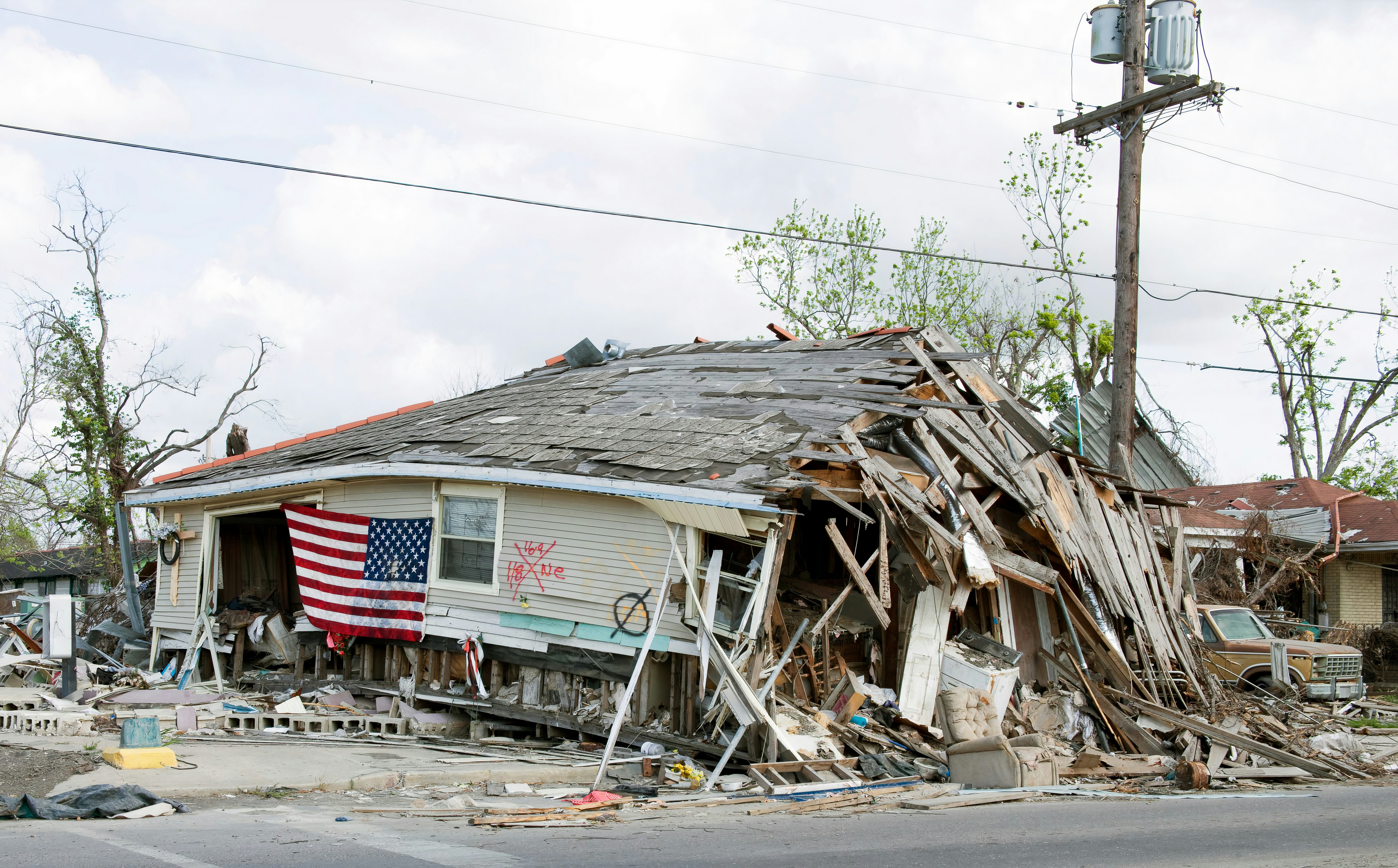 Disaster aftermath — collapsed home with American flag